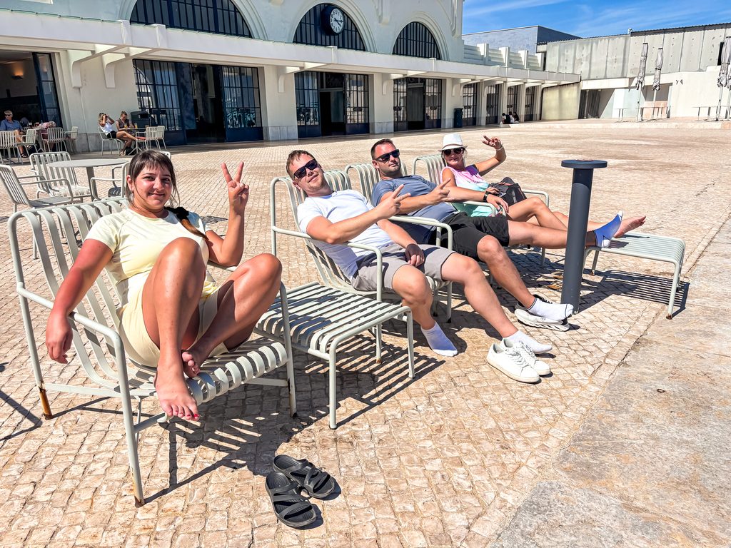 Our group relaxing on loungers near the Lisbon river cruise terminal before boarding.