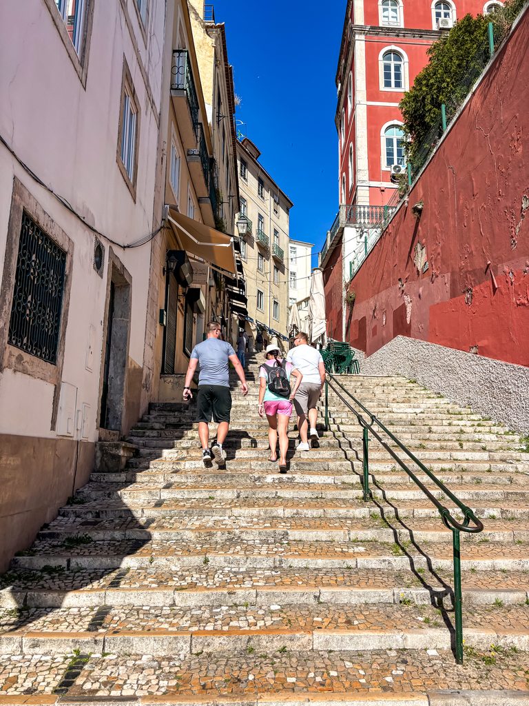 Travellers walking up steep stone steps during our one day in Lisbon.