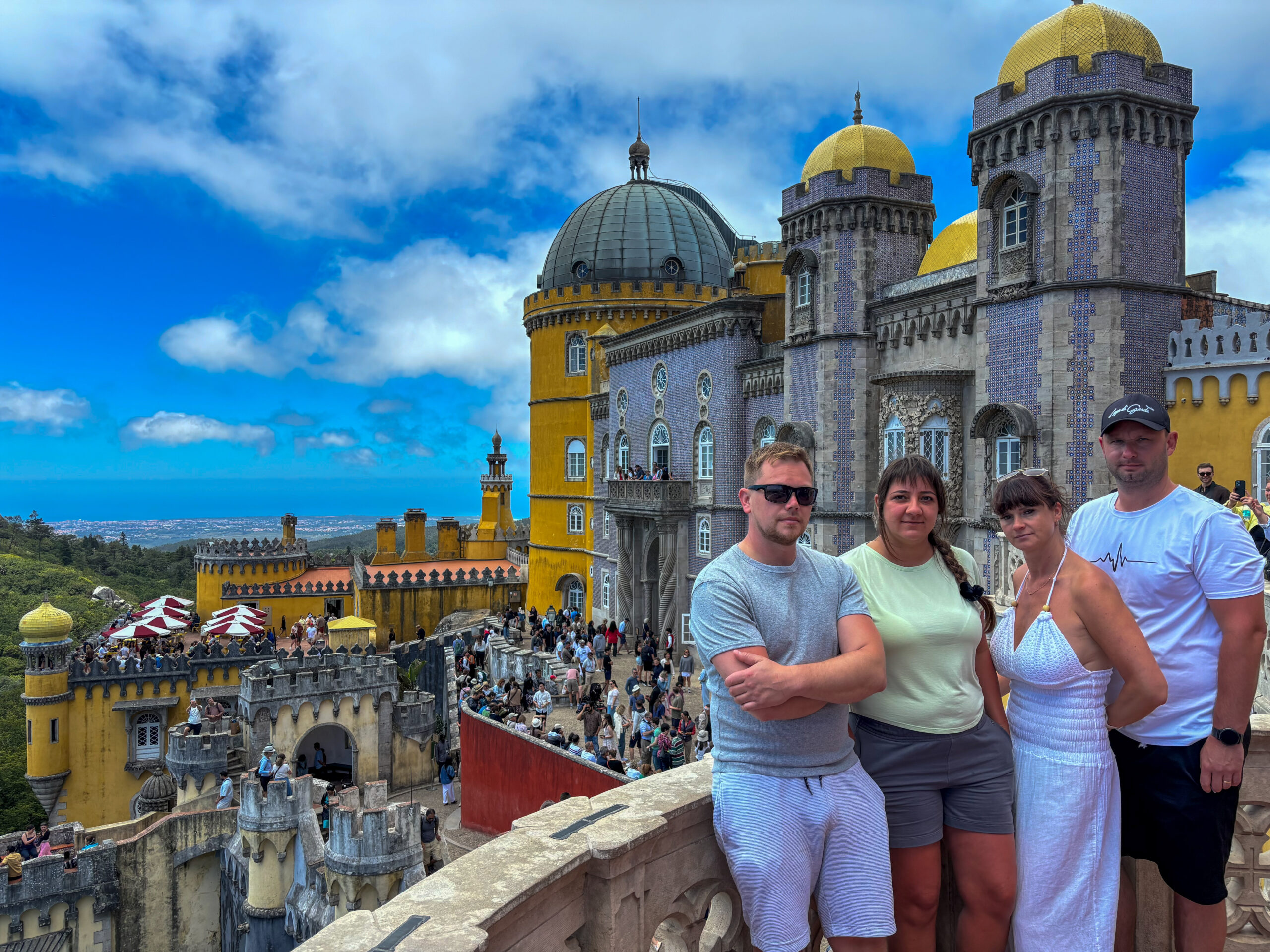 Our group at Pena Palace during our Sintra day trip from Lisbon, with the colourful palace and Sintra hills behind us.